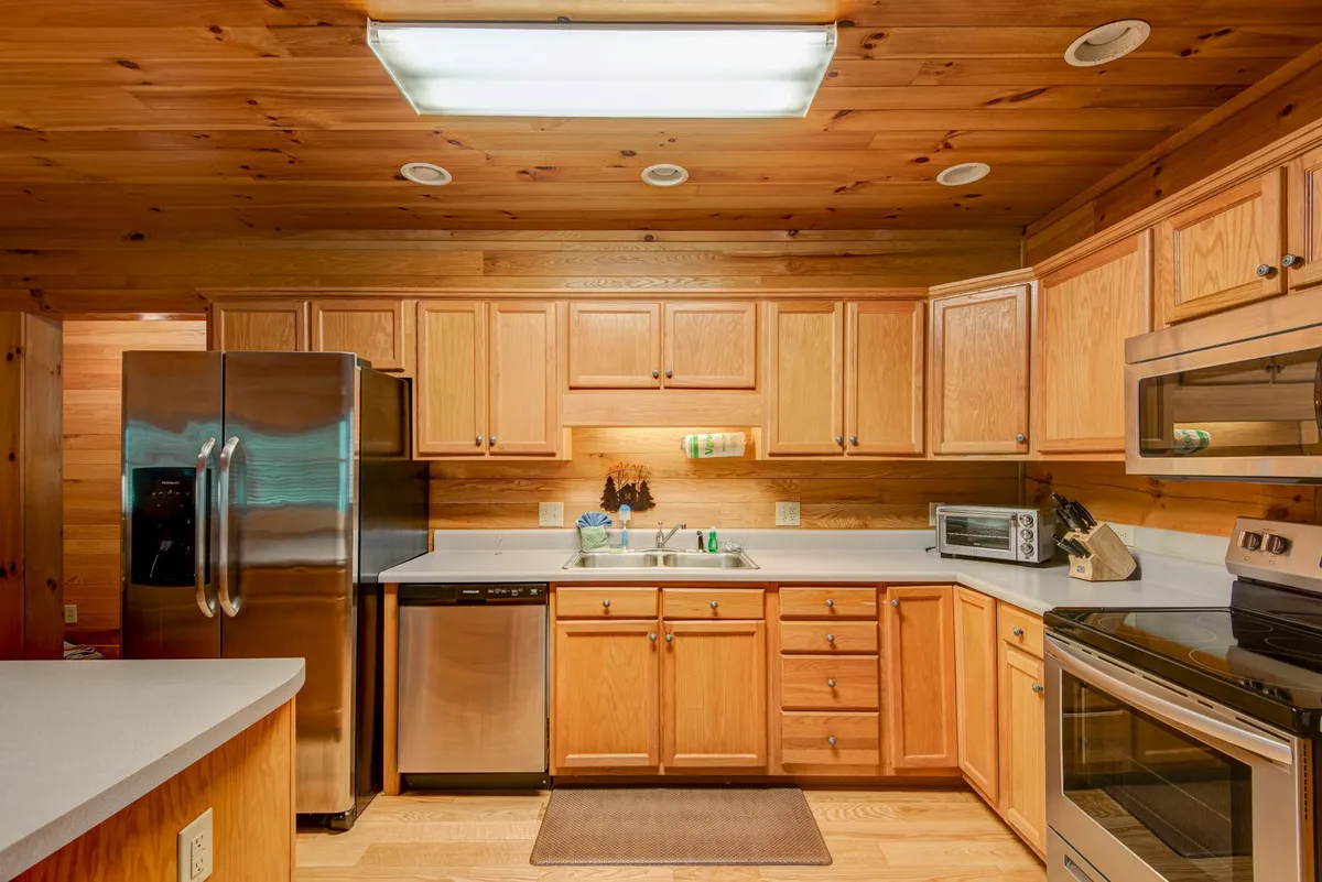 A well-equipped kitchen featuring stainless steel appliances, ample wooden cabinetry, and generous countertop space, ideal for group meal preparations and celebrations. The layout supports collaborative cooking experiences and shared laughter.